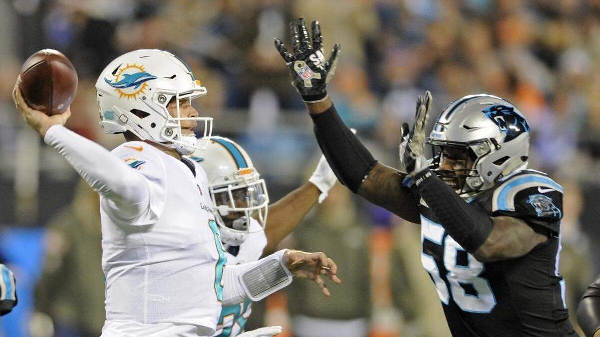 Miami Dolphins' Jay Cutler (6) looks to pass under pressure from Carolina Panthers' Thomas Davis (58) in the first half of Monday night’s game. The Miami offense struggled against the Panthers defense in the 45-21 loss.