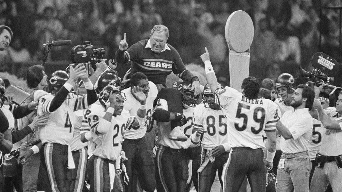 In this Jan. 26, 1986, file photo, Chicago Bears defensive coordinator Buddy Ryan is carried off the field by the team after the Bears beat the New England Patriots 46-10 in Super Bowl XX in New Orleans. In the picture, Carolina Panthers coach Ron Rivera (59) salutes the man he considered a mentor.