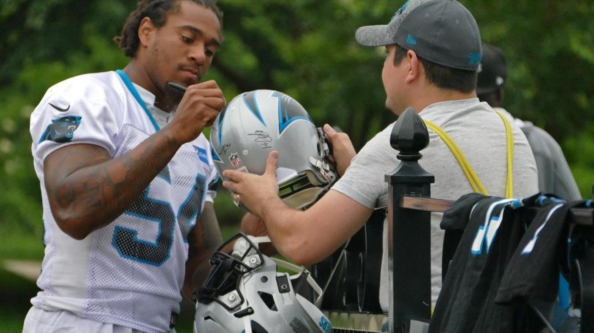 Linebacker Shaq Thompson signs a helmet for fan Ryan Self before Carolina Panthers OTA practice on Tuesday. Carolina will count on Thompson’s versatility to combat the new weapons in the NFC South.