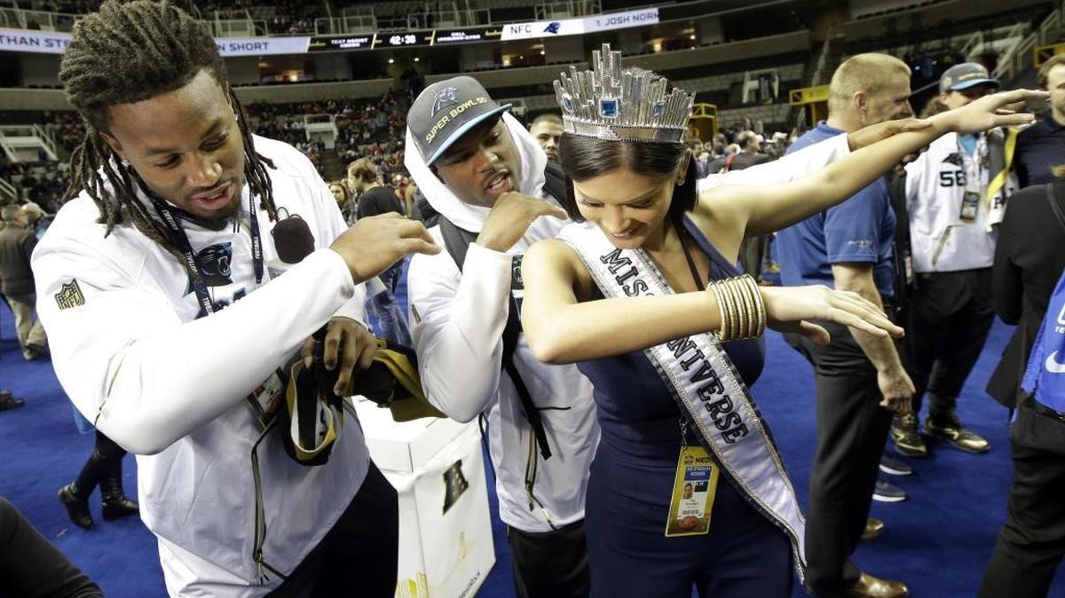 Carolina Panthers players Ryan Delaire and Bene' Benwikere dab with Miss Universe Pia Alonzo Wurtzbach during Opening Night for the NFL Super Bowl 50.