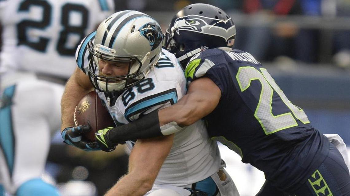 Carolina Panthers' Greg Olsen (88) gets wrapped up by Seattle Seahawks' Cary Williams (26) in the second half at CenturyLink Field on Sunday, October 18, 2015. The Panthers won 27-23.