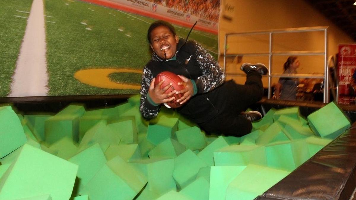 A fan dives into a foam pit to catch a football at the Moscone Center West in San Francisco.