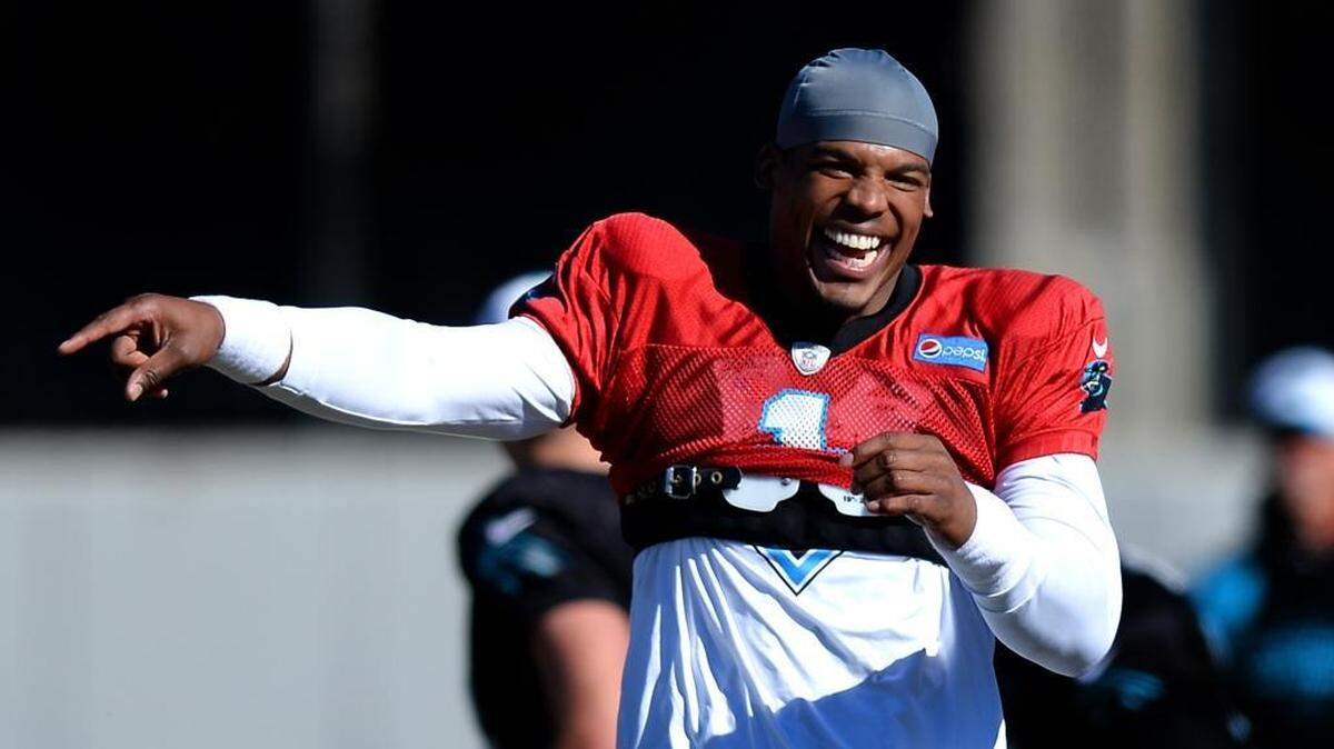 Carolina Panthers quarterback Cam Newton laughs at the dancing of teammates before practice on Friday.