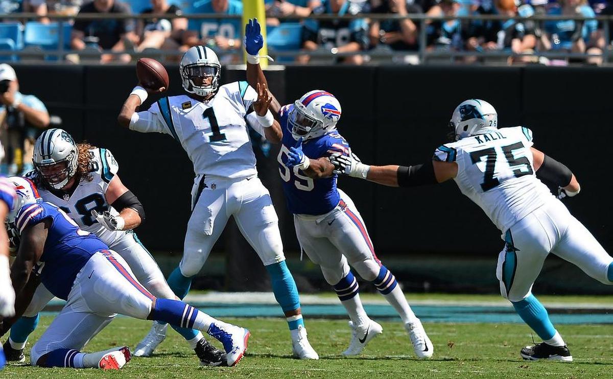 Carolina Panthers quarterback Cam Newton passes to running back Christian McCaffrey while being pressured by Buffalo Bills defensive end Jerry Hughes during third quarter action on Sunday, September 17, 2017 at Bank of America Stadium in Charlotte, NC. The Panthers defeated the Bills 9-3.