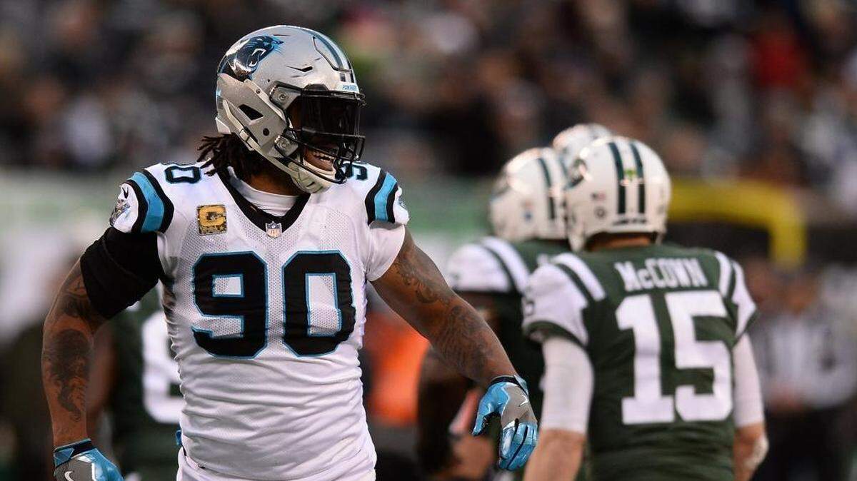 Carolina Panthers defensive end Julius Peppers, left, smiles after sacking New York Jets quarterback Josh McCown, right, during Sunday’s game. The two are close friends and entered the NFL in the same year.