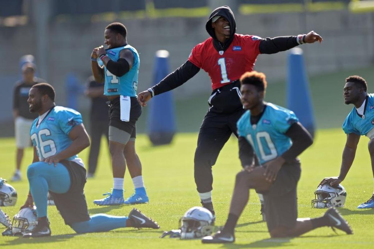 Carolina Panthers quarterback Cam Newton dances at Wednesday’s practice while his teammates stretch. Newton, who – even though he wasn’t participating – managed to get under the defense’s skin by taunting defenders after big offensive plays during OTAs and minicamp.