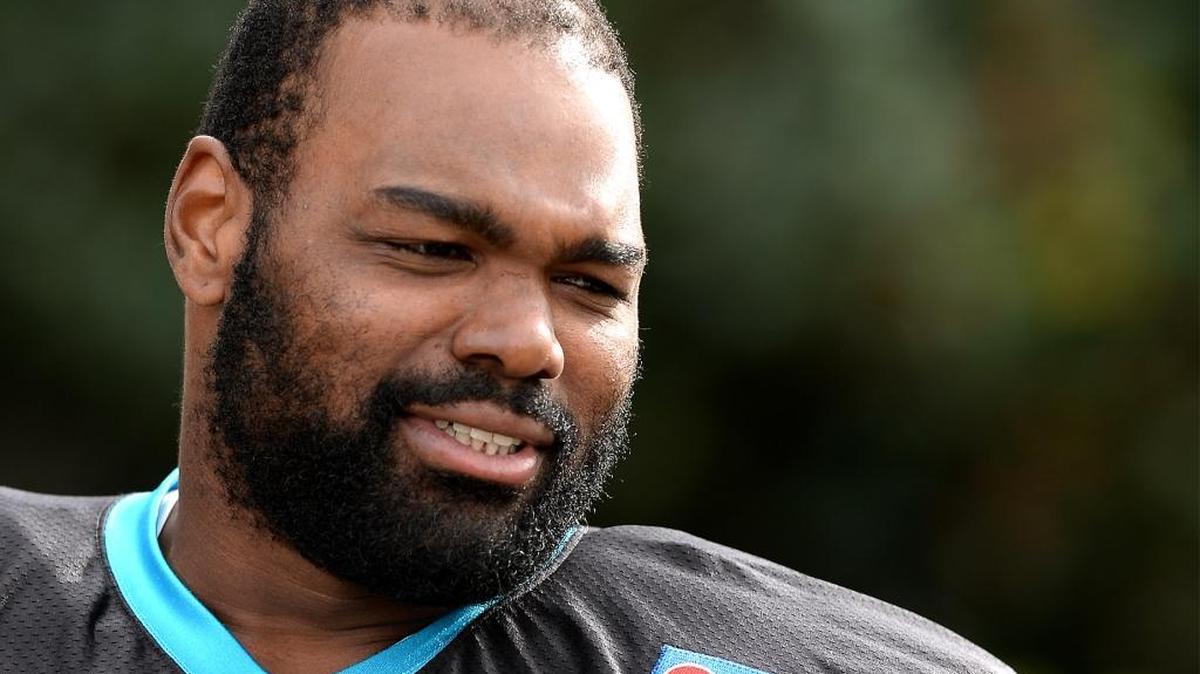 Carolina Panthers left tackle Michael Oher smiles at a fan as he walks to practice on Wednesday, November 18, 2015.