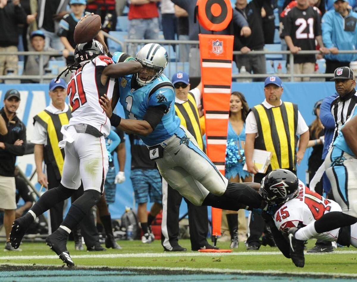 Carolina Panthers' Cam Newton (1) dives over the goal line for a touchdown against Atlanta Falcons' Desmond Trufant (21) and Deion Jones (45) in the first half of an NFL football game in Charlotte, N.C., Sunday, Nov. 5, 2017. (AP Photo/Mike McCarn)