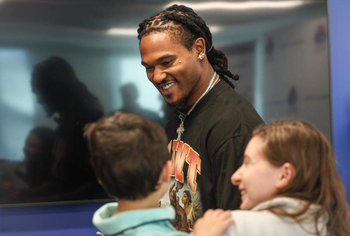Panthers running back Rico Dowdle smiles at a young fan at Children’s Home Society of North Carolina (CHS) in Charlotte, NC on Friday, November 14, 2025. Dowdle presented CHS with a check for $45,000 as a he turned a penalty into purpose, transforming a fine for his touchdown celebration into a charitable cause.