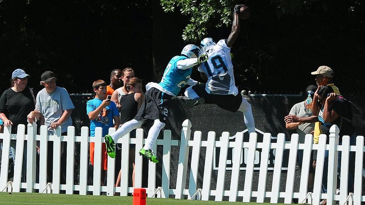 
Carolina Panthers wide receiver Ted Ginn, Jr., right, leaps over a fence after catching a deep pass from quarterback Cam Newton during practice at Wofford College in Spartanburg, S.C., on Saturday, Aug. 1, 2015. Cornerback Chris Houston, left, applied defensive pressure on the play and leapt over the fence as well as fans looked on.
