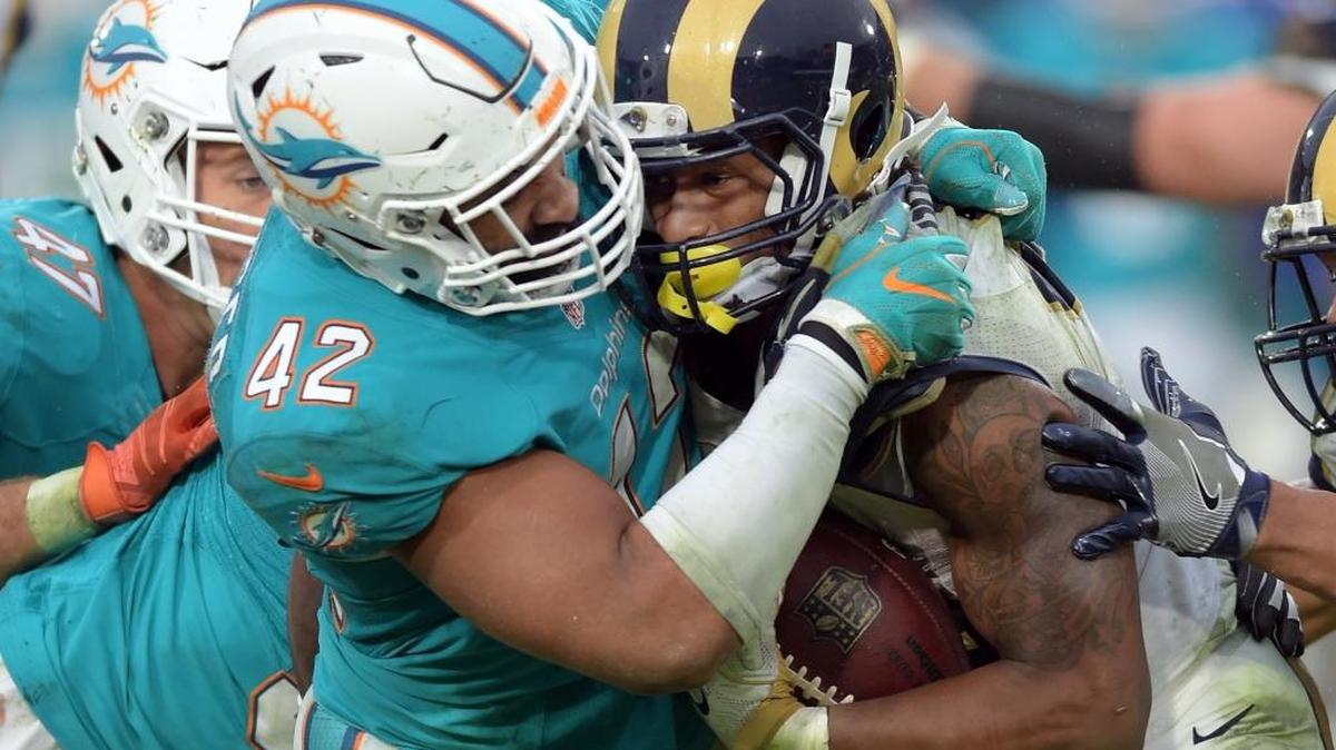 Miami Dolphins linebacker Spencer Paysinger (42) tackles Los Angeles Rams running back Todd Gurley (30) in the fourth quarter of a game played at Los Angeles Memorial Coliseum in Los Angeles on Sunday, Nov. 20, 2016. (AP Photo/John Cordes)