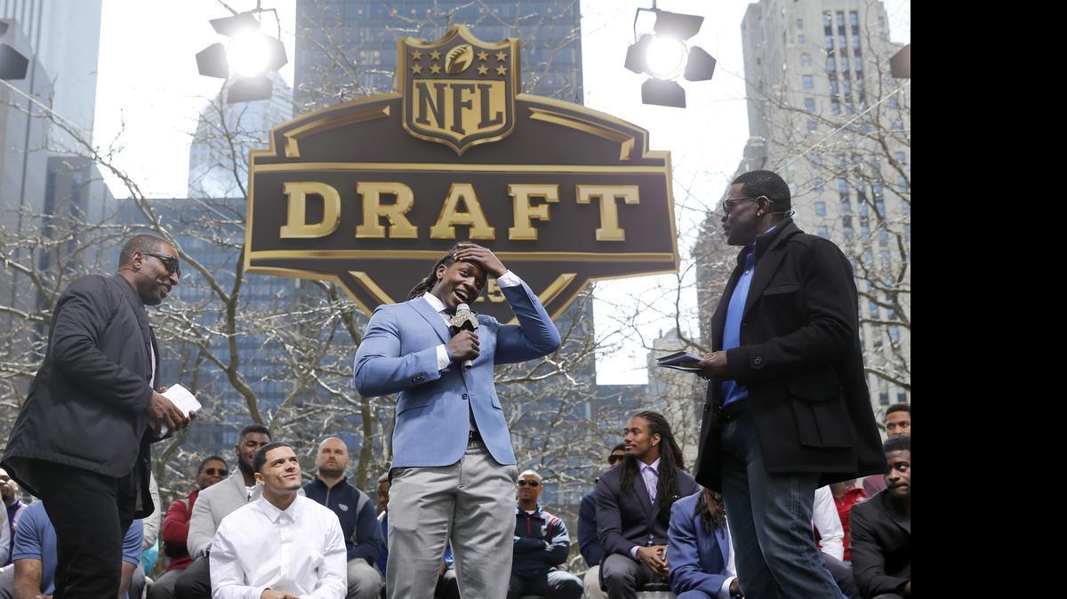 
Cris Carter, left, and Michael Irvin, right, interview Wisconsin running back Melvin Gordon during introductions at a pre-draft rally of 2015 NFL Draft prospects, and various league legends at Pioneer Court on Wednesday.
