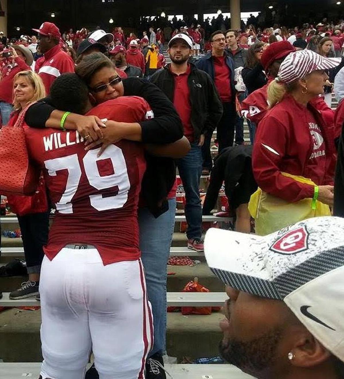 Lameca Williams-Hindman hugs her son Daryl Williams, now a Panthers offensive tackle, on the sidelines of an Oklahoma football game. When Sooners coach Bob Stoops came to her home for a recruiting visit, she served him spaghetti – and told him she expected her son to graduate.