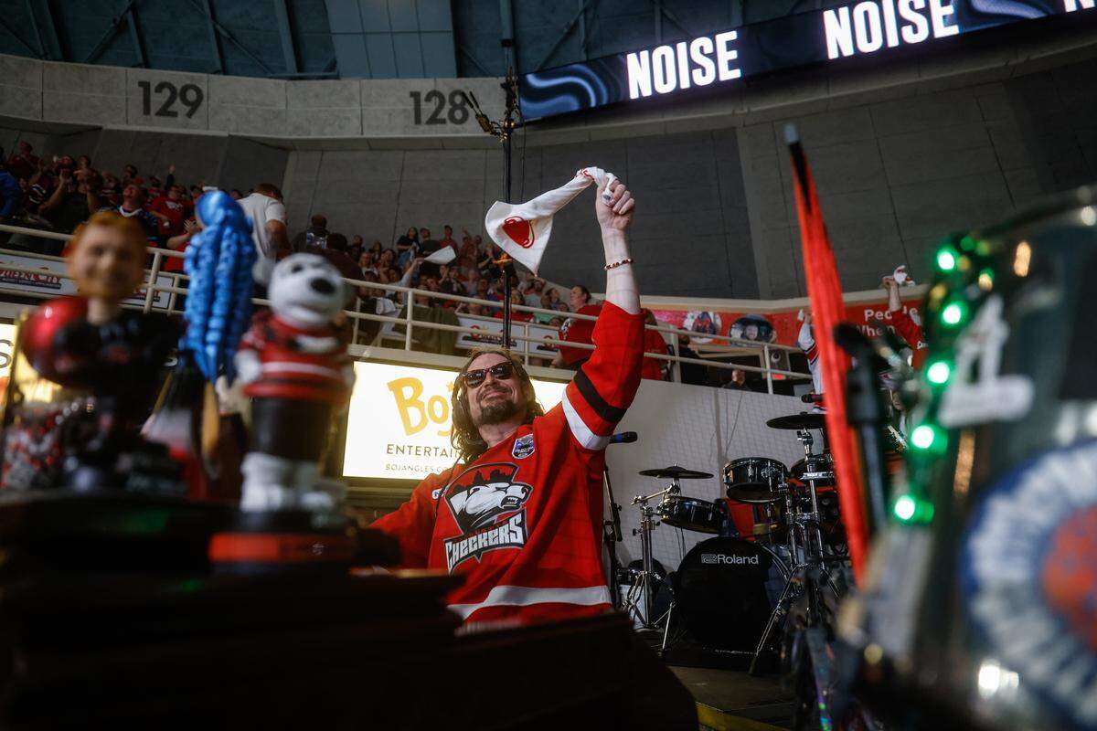 Checkers organist and keytarist Jason Atkins, also known as Greazy Keyz, waves a rally towel during the Calder Cup opener between the Checkers and Canucks at Bojangles Coliseum in Charlotte, NC on Friday, June 13, 2025.