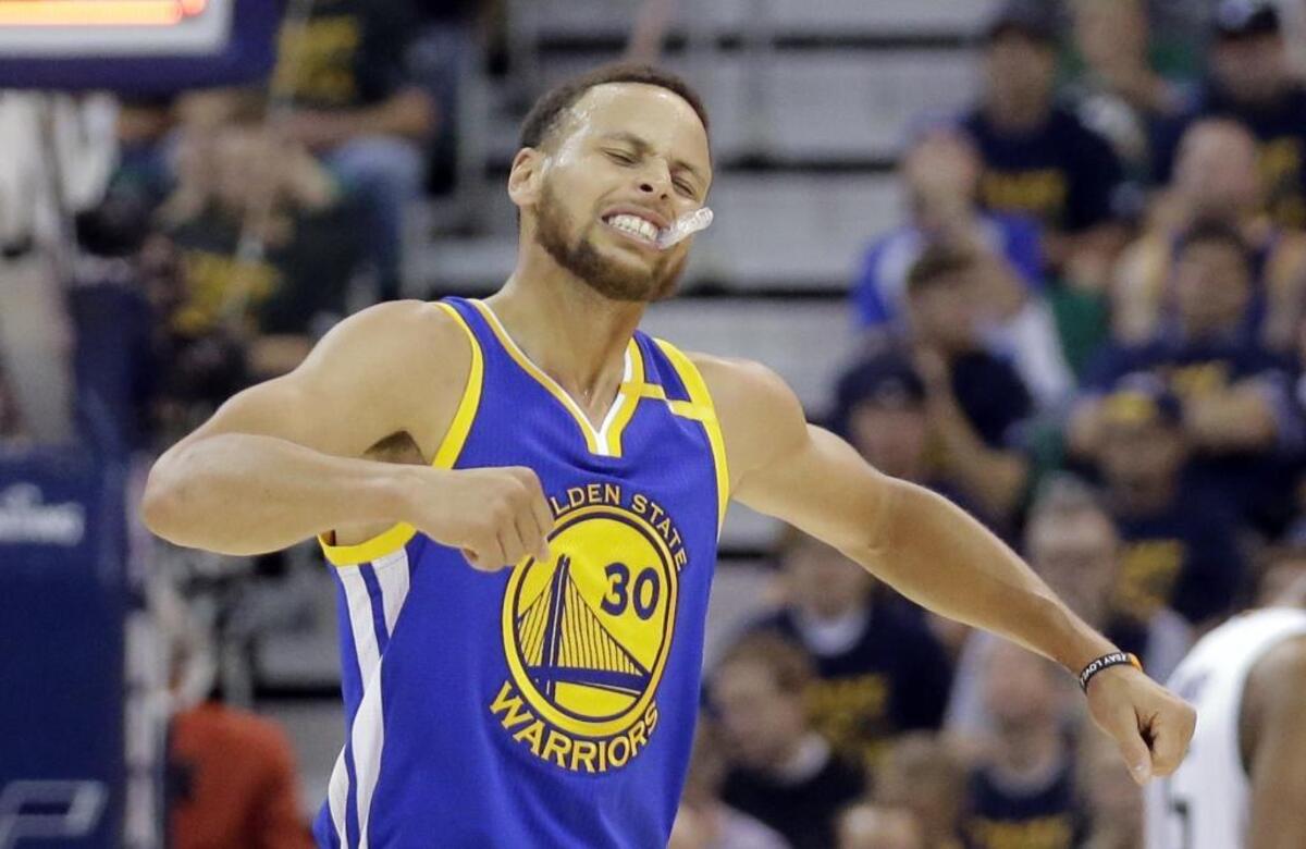 Golden State Warriors guard Stephen Curry celebrates after a teammate scored against the Utah Jazz on Monday.