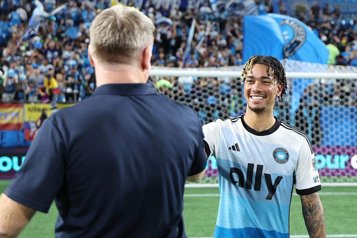 CHARLOTTE, NORTH CAROLINA - SEPTEMBER 13: Idan Toklomati #17 of Charlotte FC shakes hands with Dean Smith, Head Coach of Charlotte FC,  the MLS match between Charlotte FC and Inter Miami CF at Bank of America Stadium on September 13, 2025 in Charlotte, North Carolina. (Photo by David Jensen/Getty Images)
