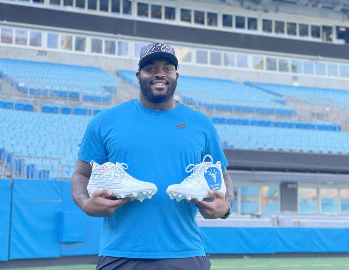 Carolina Panthers offensive lineman Taylor Moton poses with his freshly painted and designed cleats ahead of his “My Cause, My Cleats” game, focused on elevating education.