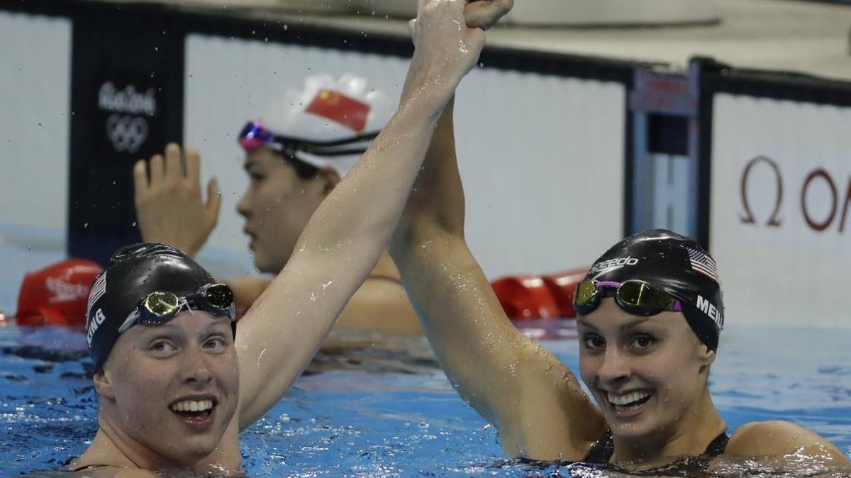 Gold medal winner Lilly King, left, of the United States celebrates with bronze medal winner Katie Meili after the final of the women’s 100-meter breaststroke on Monday night. Meili trains at SwimMAC Carolina.