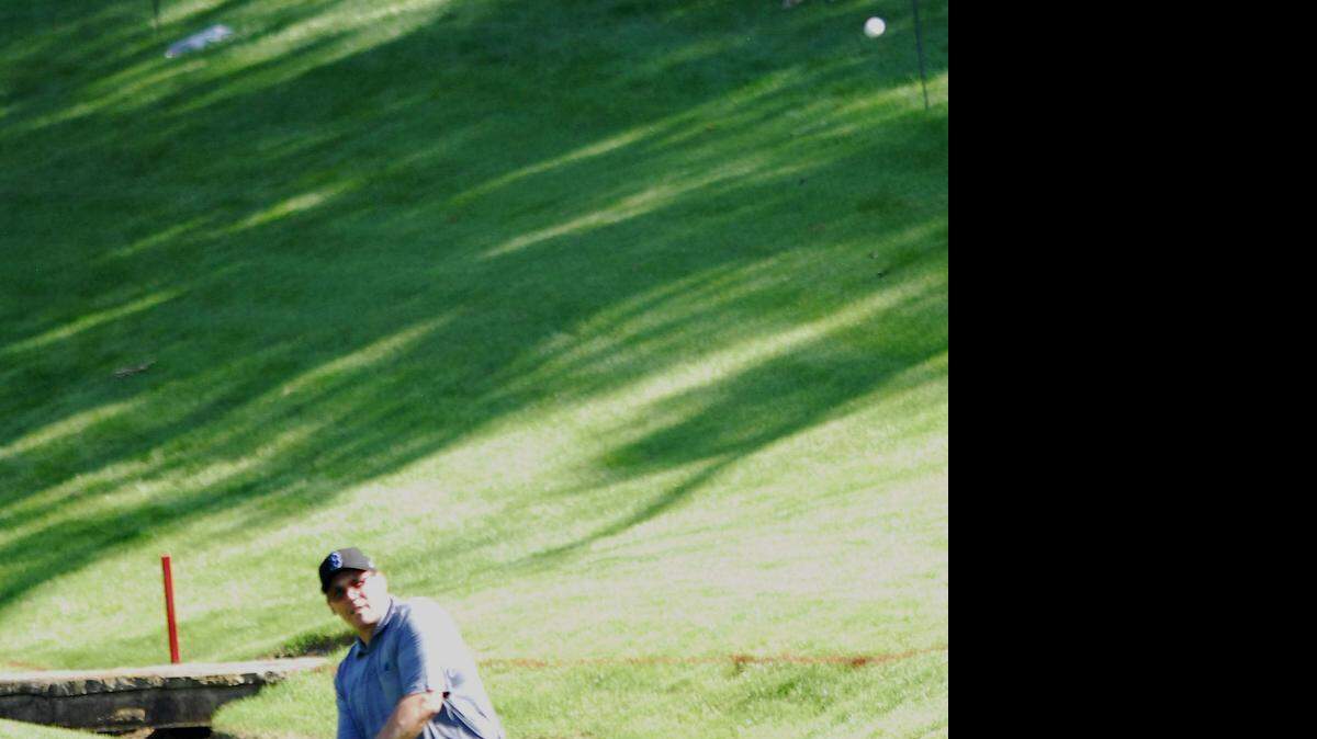 
Ron Rivera tries to chip his way out of the bank of a creek at the 18th green at Quail Hollow Club in Charlotte, Wednesday, May 13, 2015.
