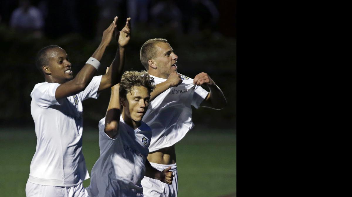 
Charlotte Independence defenders Bilal Duckett (15) and Patrick Slogic (4) celebrate a goal scored by teammate Jorge Herrera, middle, against the New England Revolution in the second half of a U.S. Open Cup soccer match Wednesday, June 17, 2015, in Boston. The Independence won 1-0.
