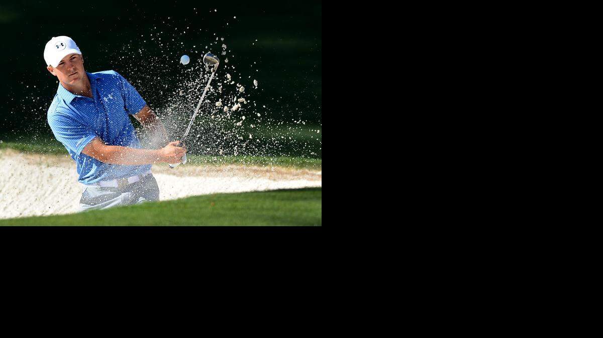 
Jordan Spieth, who has held the lead since the first round, blasts a shot out of the bunker at the 10th green during the third round of Saturday’s Masters tournament at Augusta National Golf Club. 
