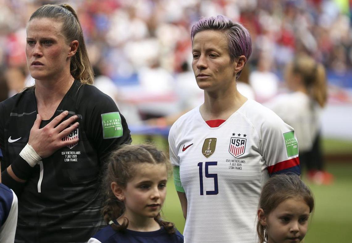 Alyssa Naeher stands next to U.S. teammate Megan Rapinoe during the national anthem before the Women’s World Cup final soccer match against the Netherlands.