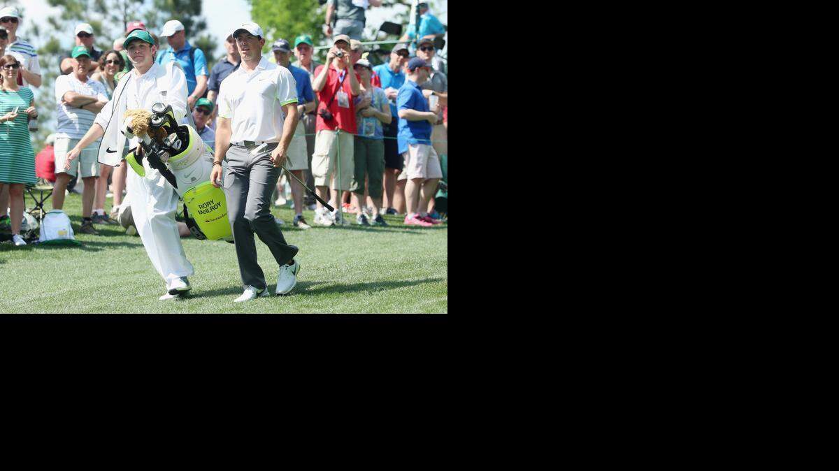 
Rory McIlroy of Northern Ireland walks alongside his caddie Niall Horan of the band One Direction during the Par 3 Contest prior to the start of the 2015 Masters Tournament at Augusta National Golf Club on Wednesday at Augusta, Ga. McIlroy would complete golf’s career slam – victories at each of the four majors – if he wins this week. 
