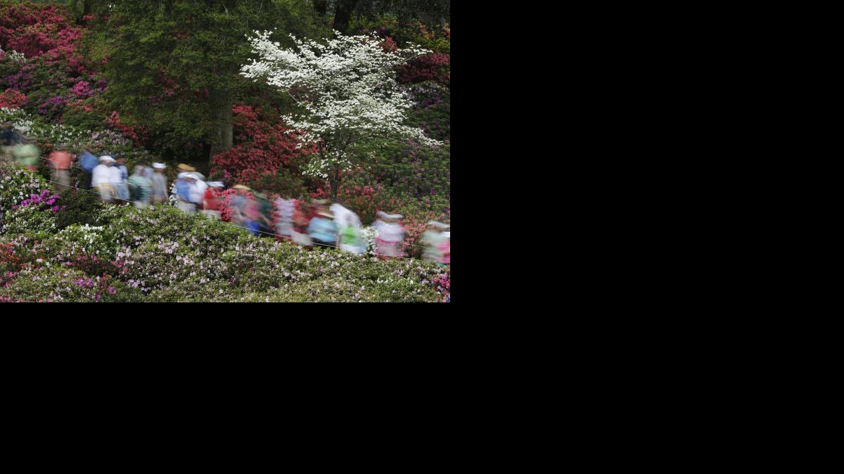 
Spectators walk past colorful azaleas adjacent to the sixth fairway during a practice round for the Masters golf tournament Monday in Augusta, Ga. 
