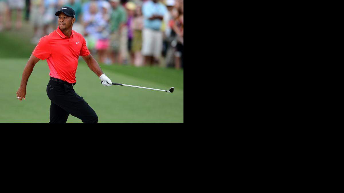 
Tiger Woods watches his ball after hitting from a sand trap along the 10th green during the championship round of the Masters Tournament at Augusta National Golf Club on Sunday, April 12, 2015. 
