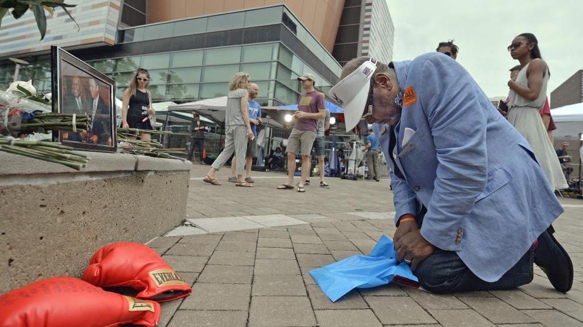 Frank Green, of Louisville, Ky., kneels to pray at a memorial for Muhammad Ali at the Muhammad Ali Center, Saturday in Louisville Ky.