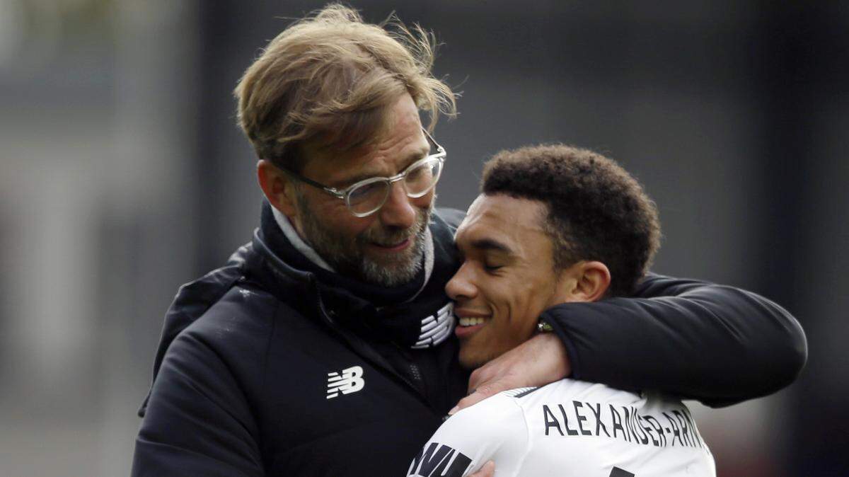 Liverpool's manager Jurgen Klopp, hugs Trent Alexander-Arnold as they celebrate after the English Premier League soccer match between Crystal Palace and Liverpool at Selhurst Park stadium in London, Saturday, March 31, 2018. Liverpool won the game 2-1. (AP Photo/Alastair Grant)