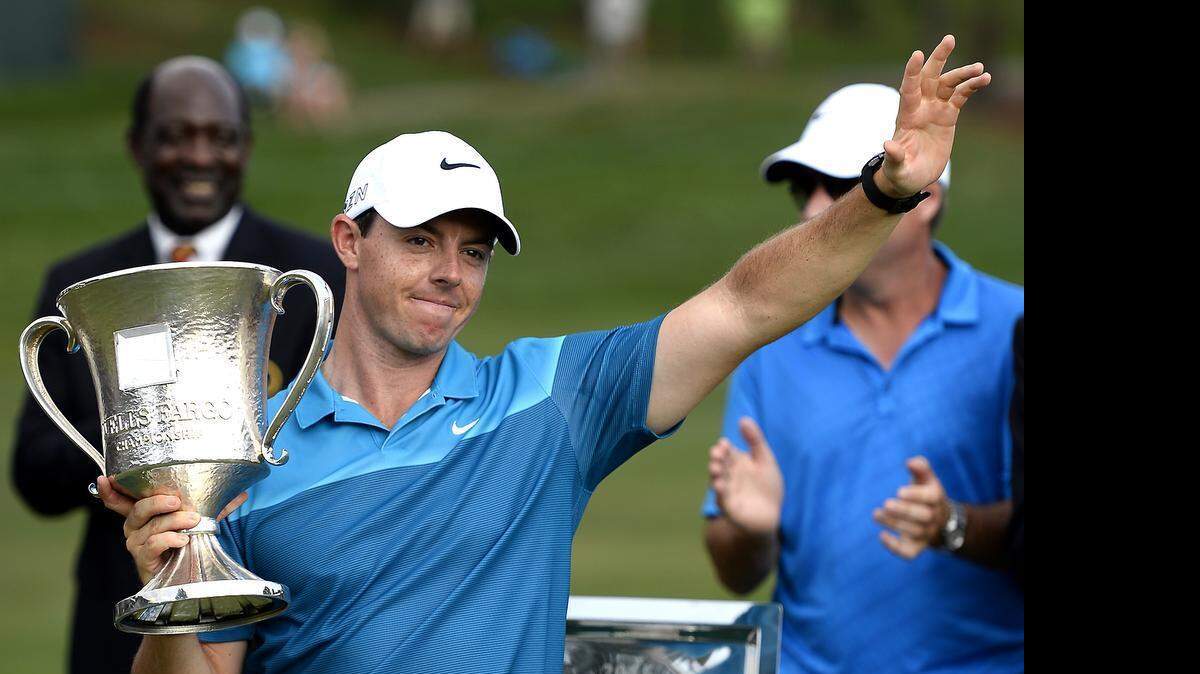 
Rory McIlroy waves to cheering fans after being presented with the Wells Fargo Championship trophy on Sunday, May 17, 2015 at Quail Hollow Club in Charlotte. McIlroy won the tournament after finishing the final round at -21.
