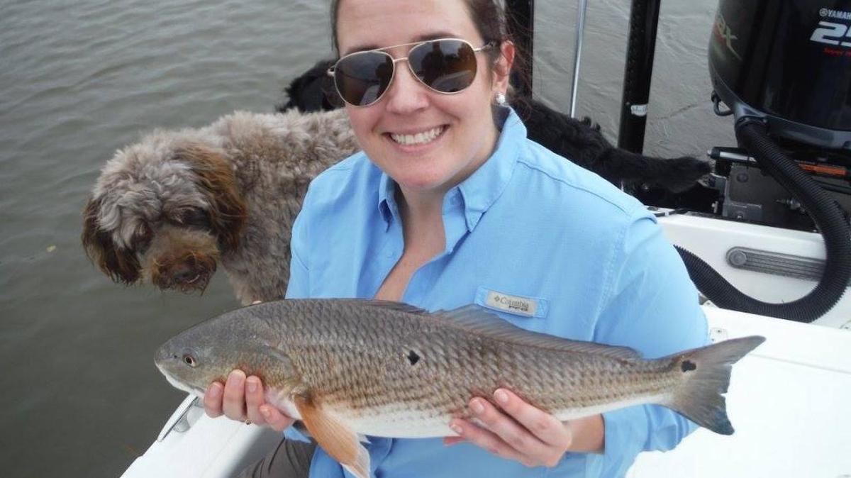 Jessica Owens of Charleston with a plump redfish, or spottail, she boated recent in backwaters along the lower S.C. Coast. She was fishing with husband Simon, a guide and sporting goods store employee. The Owens caught and released numerous reds while sight-casting to a school sunning on a mud flat. Their poodle/terrier mix, Finley, obviously approves.
