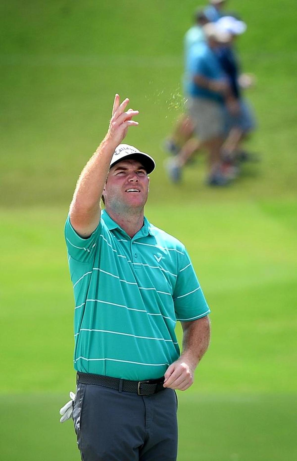 Grayson Murray checks the direction of the wind by tossing blades of grass into the air during the first round of the PGA Championship at Quail Hollow Club. Murray, who is from Raleigh and attended Wake Forest and East Carolina, shot a 3-under 68.