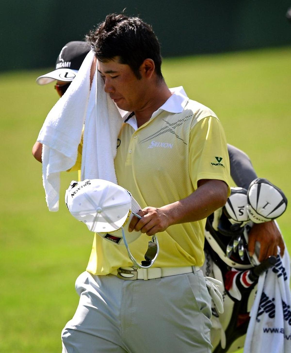 Hideki Matsuyama wipes away sweat as he walks down the seventh fairway during Saturday’s third round of the PGA Championship at Quail Hollow Club in Charlotte.