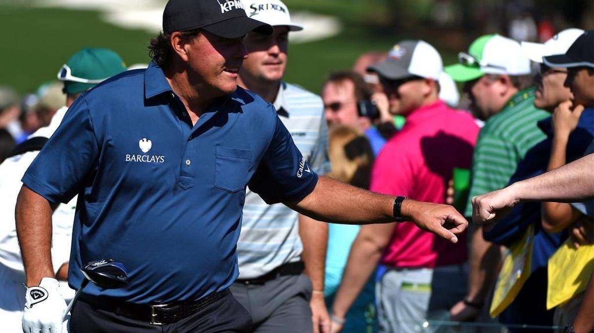 Three-time Masters champion Phil Mickelson reaches greets fans as he walks to the 10th tee during Tuesday’s practice round at Augusta National Golf Club.