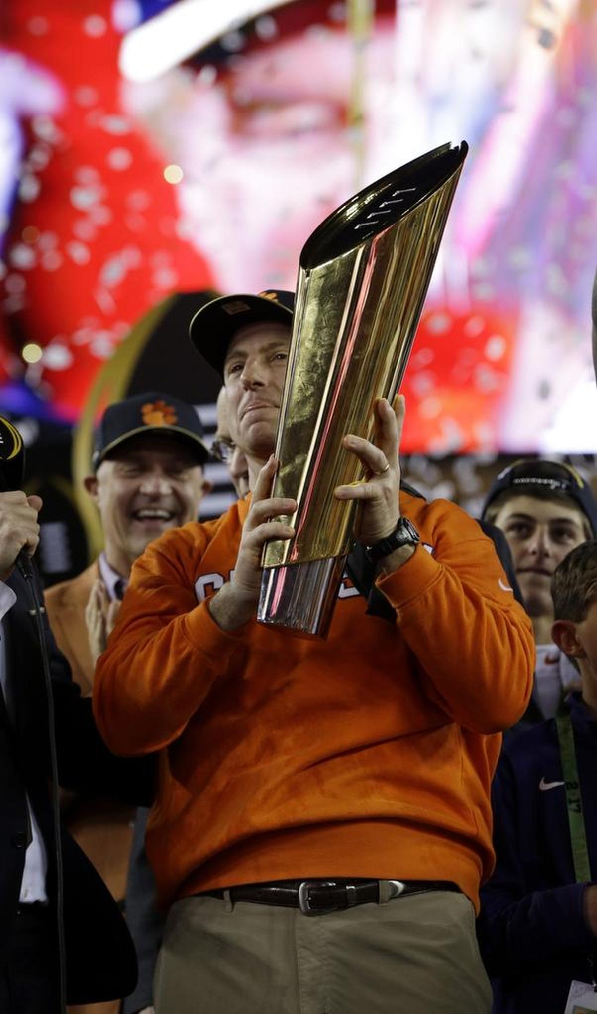 In January, Clemson football coach Dabo Swinney proudly holds the national championship trophy after the Tigers beat Alabama for the title in Tampa, Fla.