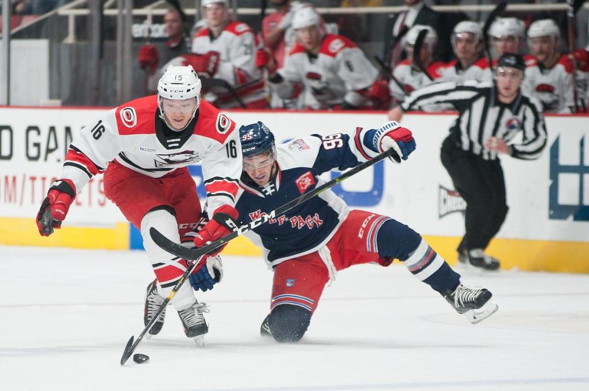 Charlotte Checkers’ Cliff Pu (16) beats Hartford Wolf Pack’s Vinni Lettieri (95) to the puck during the first period Thursdayat Bojangles’ Coliseum.