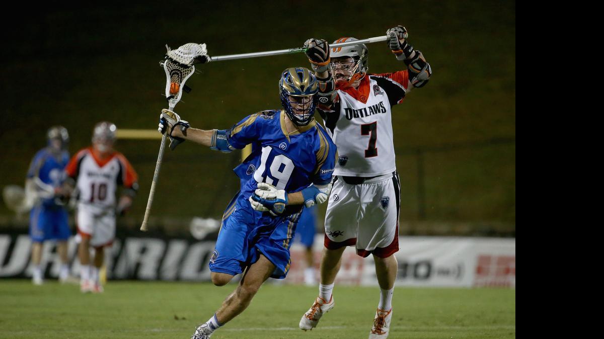 
Kevin Drew (19) of the Charlotte Hounds keeps the ball away from Denver’s Matt Bocklet during their game at Saturday at Memorial Stadium.

