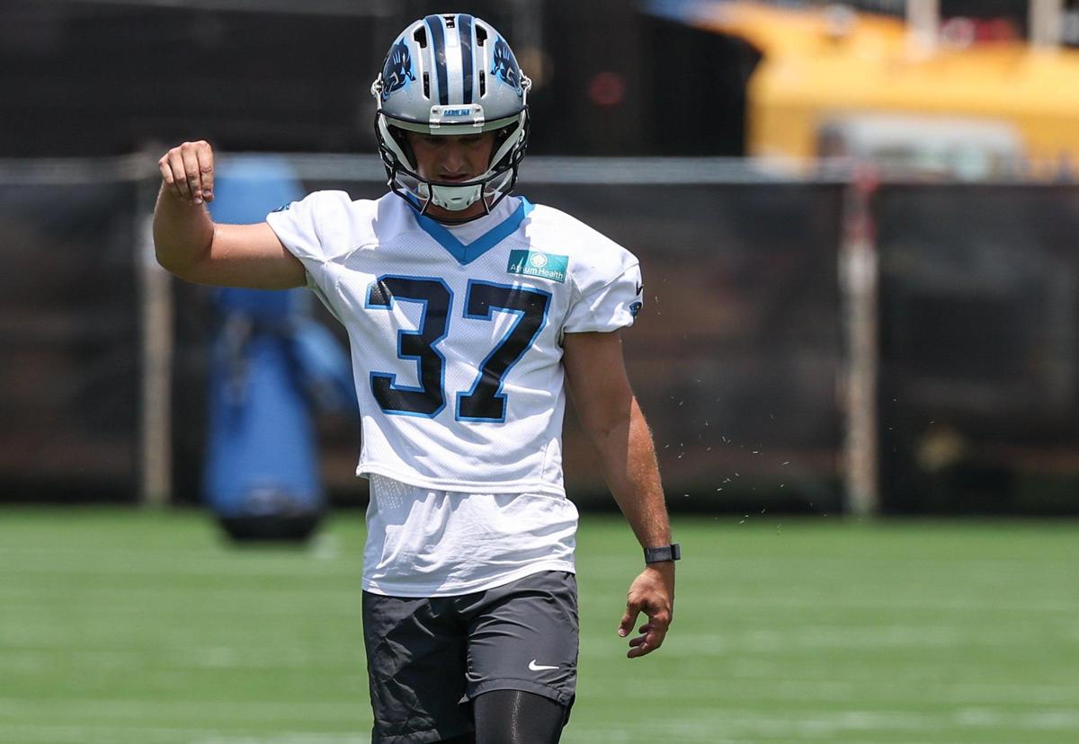 Panthers kicker Matthew Wright lets grass trickle through the air to see which way the wind is blowing before practicing a kick during the second day of minicamp in Charlotte, NC on Wednesday, June 11, 2025.