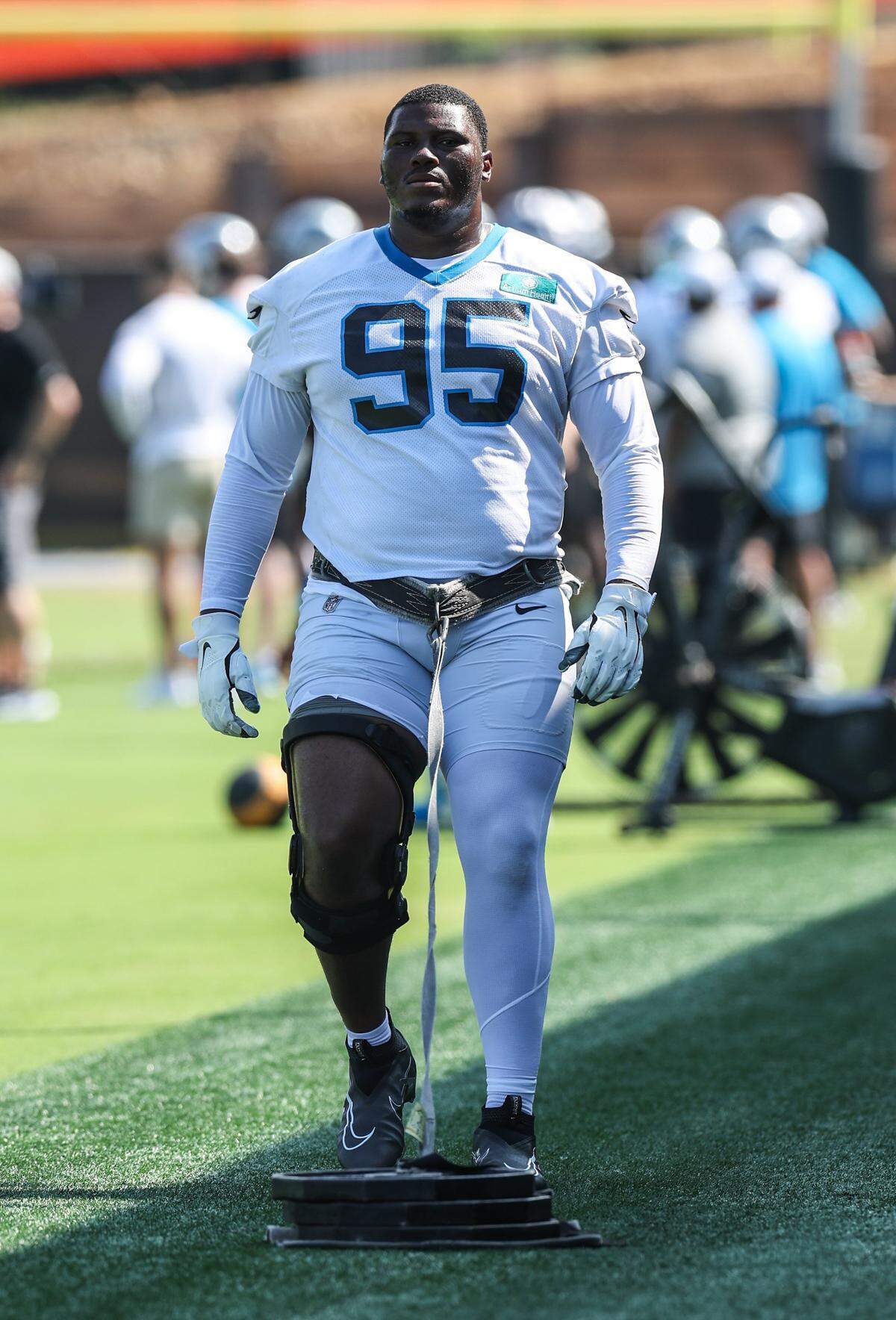 Panthers defensive end Derrick Brown pulls a weighted sled with a brace on his right leg before practice during training camp in Charlotte, NC on Tuesday, July 29, 2025.