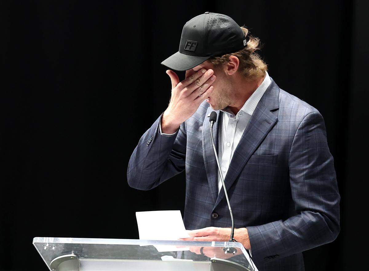 Garrett Mitchell wipes tears from his eyes as he speaks during a memorial ceremony at Bojangles Coliseum in Charlotte on Jan. 16 for the seven victims of the Biffle plane crash.