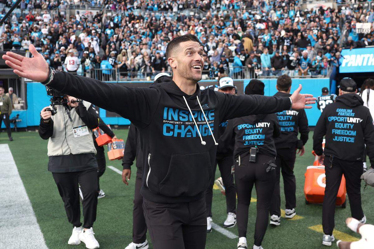 Carolina Panthers head coach Dave Canales holds his arms wide open to hug members of his team following their 23-20 victory over the Tampa Bay Buccaneers on Sunday, December 21, 2025 at Bank of America Stadium in Charlotte, NC.