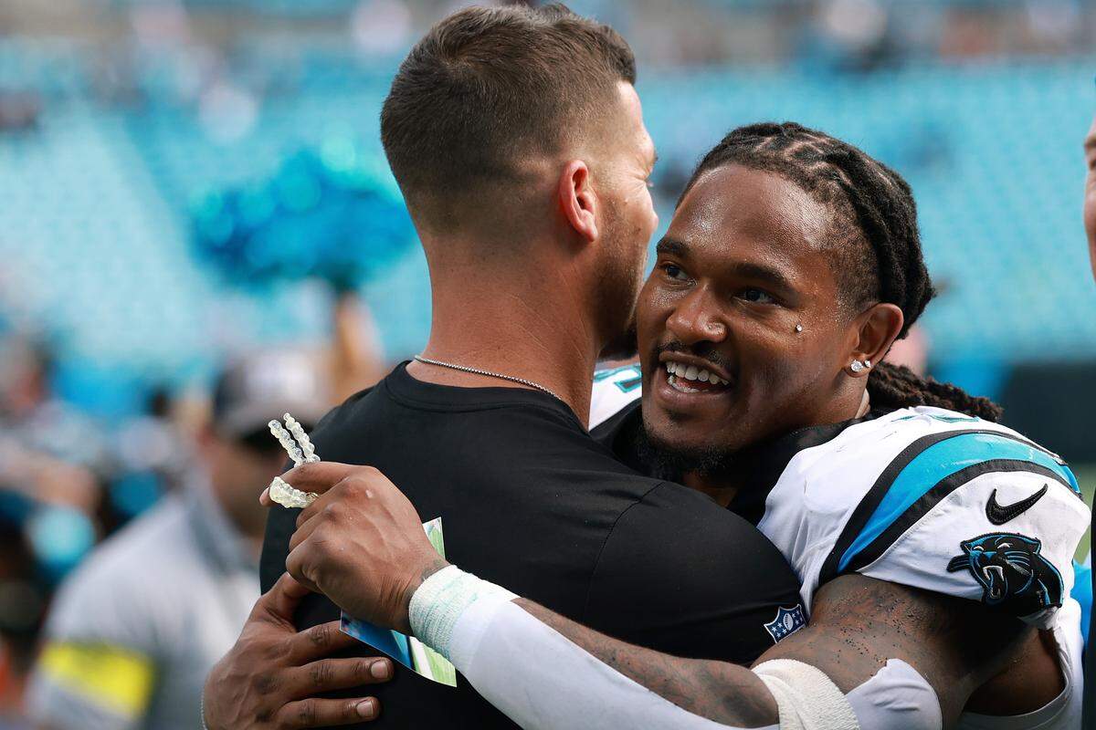 Carolina Panthers head coach Dave Canales and Rico Dowdle hug after the 27-24 early October win against the Miami Dolphins.