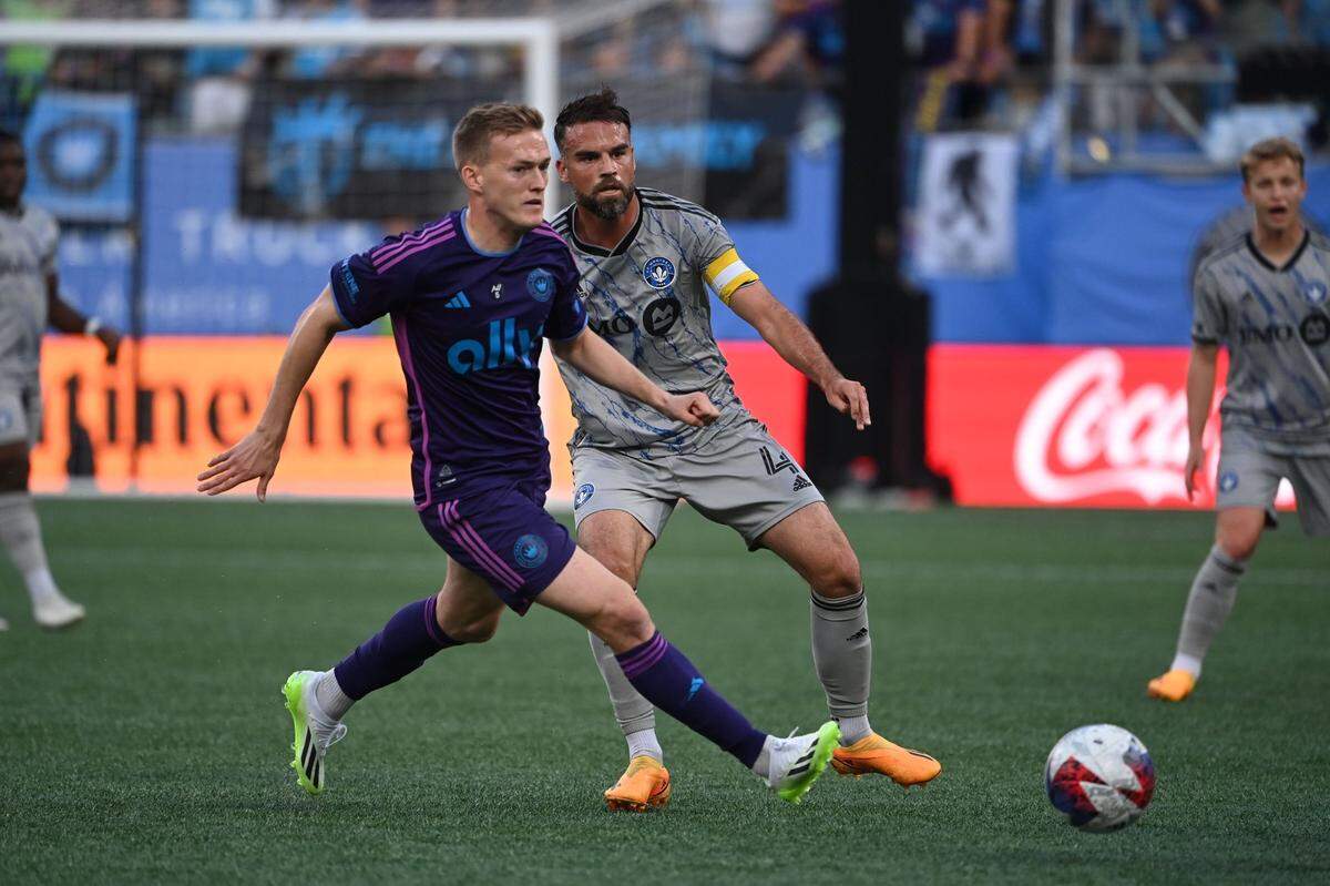 Jun 24, 2023; Charlotte, North Carolina, USA; Charlotte FC forward Karol Świderski (11) with the ball as CF Montréal defender Rudy Camacho (4) defends in the first half at Bank of America Stadium. Mandatory Credit: Bob Donnan-USA TODAY Sports