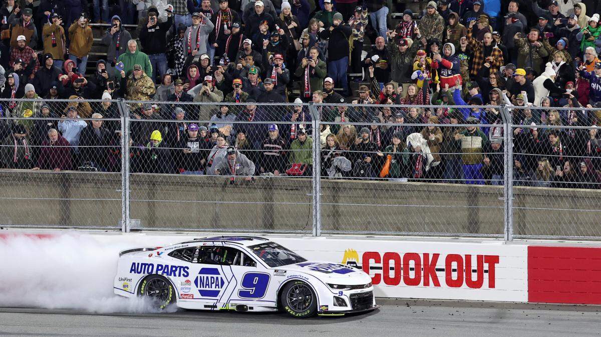Fans look on as NASCAR Cup Series driver Chase Elliott does a burnout along the backstretch safety barrier while celebrating his winning the Cook Out Clash race at Bowman Gray Stadium in Winston-Salem, NC on Sunday, February 2, 2025.