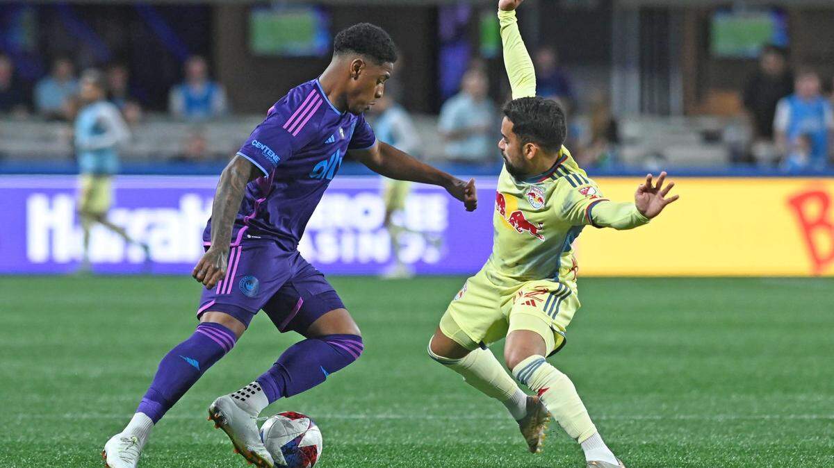 Mar 25, 2023; Charlotte, North Carolina, USA; Charlotte FC attacker Vinivius Mello (21) dribbles past New York Red Bulls attacker Luquinhas (82) in the second half at Bank of America Stadium. Mandatory Credit: Griffin Zetterberg-USA TODAY Sports