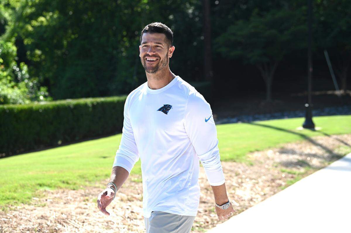 Carolina Panthers head coach Dave Canales smiles and greets passers-by as he walks to the team’s training camp practice on Wednesday, July 23, 2025.
