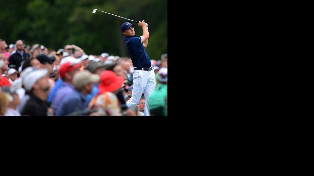 
Jordan Spieth, right, watches his drive from the 12th tee box with the gallery during the championship round of the Masters Tournament at Augusta National Golf Club on Sunday, April 12, 2015. 
