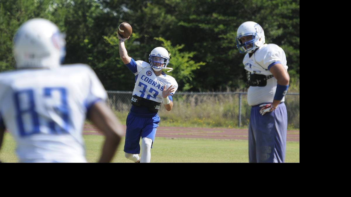 
Cobra quarterback Mark Brown (32), a Charlotte firefighter, passes to wide receiver Daryl Green (83), CMPD officer, under the watchful eye of tight end Kevin Wiggins (27), also a CMPD officer, during a practice at James Martin Middle School. The Cobras are made up of police officers, firefighters and a Federal agent, and most work in and around Charlotte.


